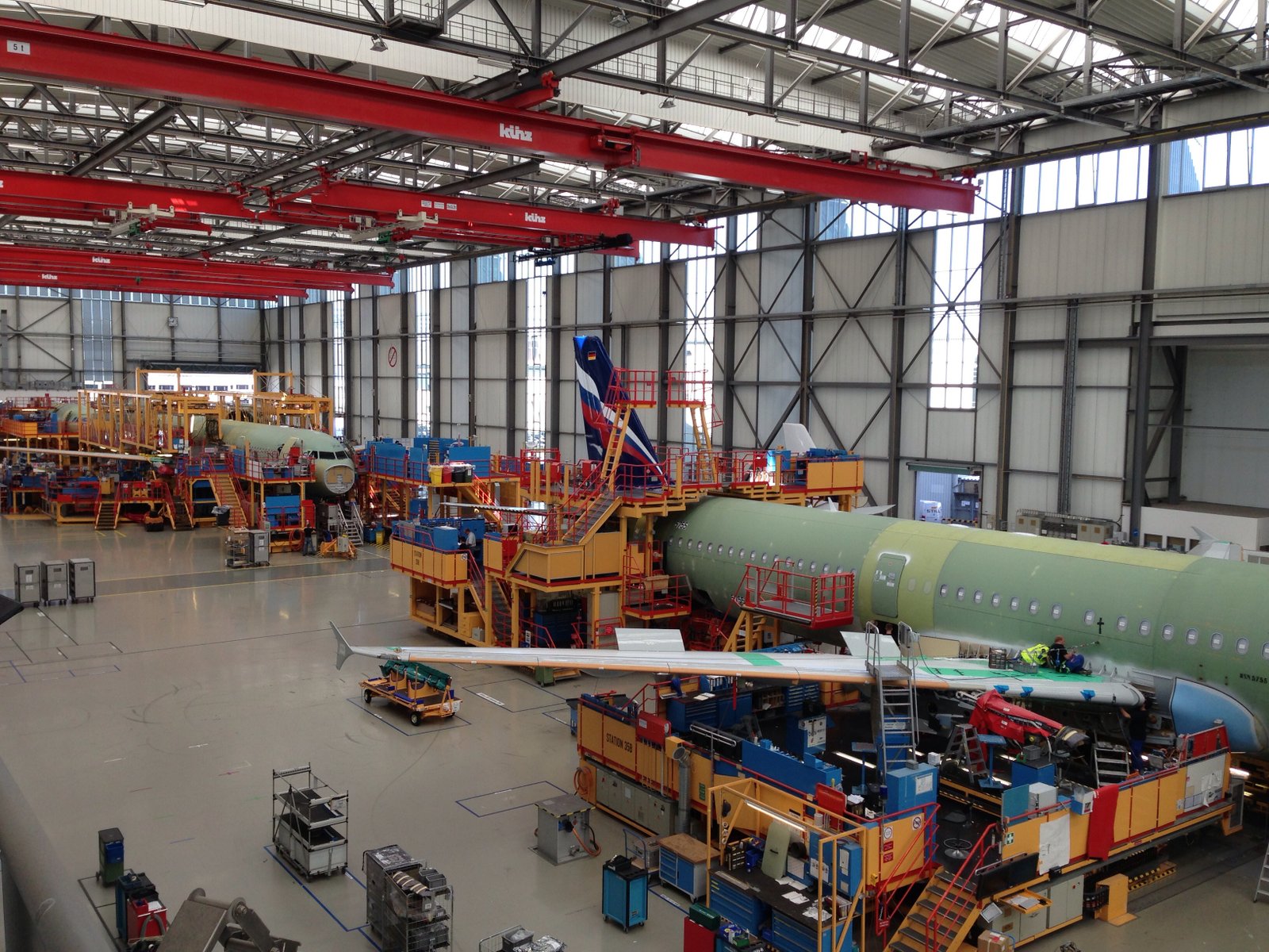 Commercial aircraft fuselage undergoing assembly inside a large Airbus production facility.