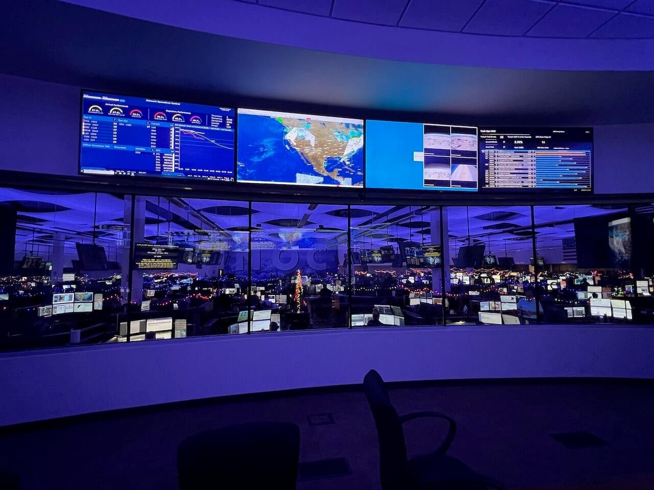 Large airline network operations centre with rows of workstations and route-monitoring screens.